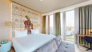 a bedroom with a large bed and a large window at nhow Amsterdam Rai in Amsterdam