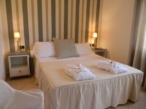 a hotel room with two towels on a bed at Relais Fenicottero Rosa in Porto San Paolo