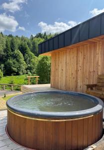 a hot tub in front of a wooden building at Mountain villa in Skhidnitsa +4 photos