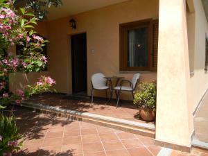 a patio with chairs and a table in a house at Relais Fenicottero Rosa in Porto San Paolo