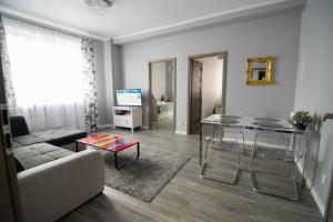 ein Wohnzimmer mit einem Sofa und einem Tisch in der Unterkunft Bright Apartment Hoza in Warschau
