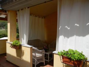 a porch with two potted plants and a chair at Relais Fenicottero Rosa in Porto San Paolo