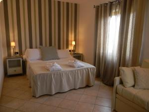 a hotel room with a bed with towels on it at Relais Fenicottero Rosa in Porto San Paolo