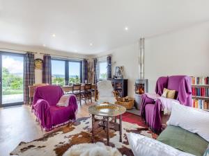 a living room with purple chairs and a table at Beautiful Highland Sanctuary in Embo
