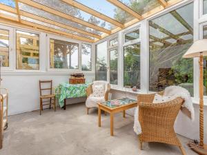 a conservatory with windows and a table and chairs at Beautiful Highland Sanctuary in Embo