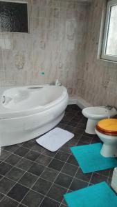 a bathroom with a tub and a toilet and mats at House near beach in Port Talbot
