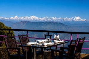 a table and chairs with a view of mountains at Hotel Hill Top Palace in Lansdowne