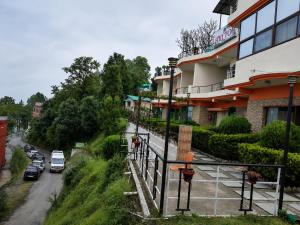 a building with cars parked on the side of a street at Hotel Hill Top Palace in Lansdowne