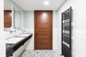a bathroom with two sinks and a wooden door at Easylife - Como Villa Sofia Apartments in Como