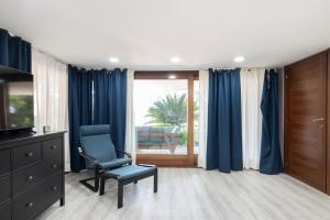 a living room with blue curtains and a chair at Easylife - Como Villa Sofia Apartments in Como