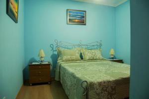 a blue bedroom with a bed and two night stands at Our Little House in Vila Real de Santo António