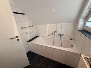 a bathroom with a bath tub with a shower at Generations Holiday City Lofts am Neumarkt Kölner Straße 23a in Attendorn