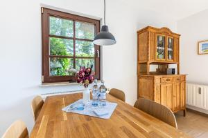a dining room table with a vase of flowers and a window at Henriette in Ahrenshoop
