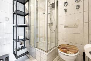 a bathroom with a shower and a toilet with a wooden seat at Henriette in Ahrenshoop +17 photos
