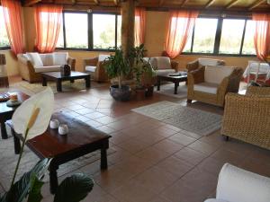 a living room with chairs and tables and windows at Relais Fenicottero Rosa in Porto San Paolo