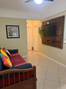 a living room with a couch and a flat screen tv at Apartamento Elizabetta 3, pé na areia in Arraial do Cabo