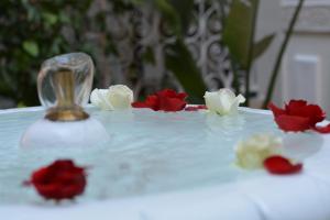 - une table blanche avec des fleurs rouges et blanches dans l'établissement Riad Karmela Princesse, à Marrakech