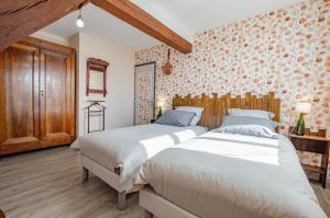 two beds in a large room with wooden walls at Le four de mimile in Montieramey
