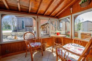 a screened in porch with chairs and a table at Le four de mimile in Montieramey