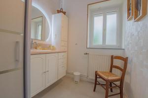 a bathroom with a chair and a sink and a window at Le four de mimile in Montieramey +29 photos