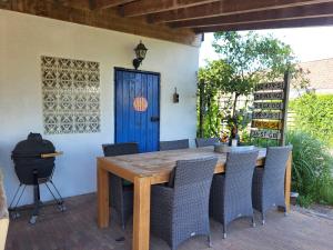a wooden table and chairs on a patio with a blue door at Bed & Breakfast de Runde in Emmer-Compascuum