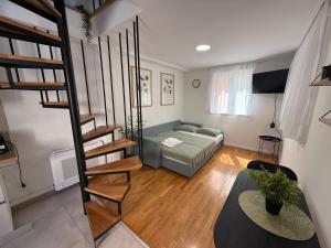 a living room with a spiral staircase and a bed at House Marin - by the beach in Igrane