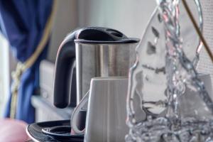 a metal tea pot sitting on top of a cup at Le Bretagne - Hôtel de charme labellisé Cosy Places in Vannes
