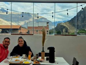 a man and a woman sitting at a table with food at VittoriaHouse in Ollantaytambo