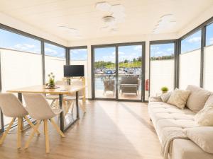 ein Wohnzimmer mit Sofa und Tisch in der Unterkunft Floatinghouse LP16 in Braunsbedra