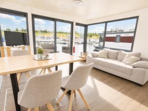 ein Wohnzimmer mit Tisch, Stühlen und Sofa in der Unterkunft Floatinghouse LP16 in Braunsbedra