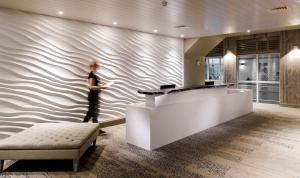 a woman standing against a wall in a lobby at Inchydoney Island Lodge & Spa in Clonakilty