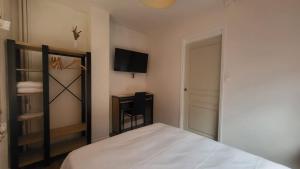 a bedroom with a bed and a tv on the wall at Chambre 8 in Le Trait +2 photos