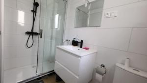 a white bathroom with a sink and a shower at Chambre 8 in Le Trait