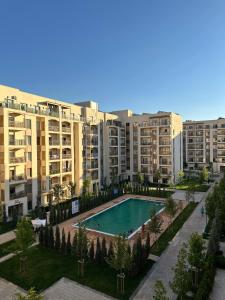 an apartment complex with a swimming pool and apartment buildings at Chorvoq Darvozasi touristic complex in Chorwoq