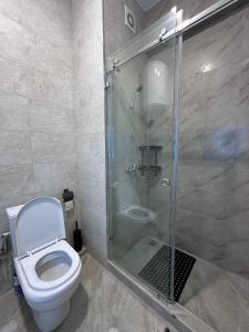 a bathroom with a toilet and a glass shower at Chorvoq Darvozasi touristic complex in Chorwoq +4 photos