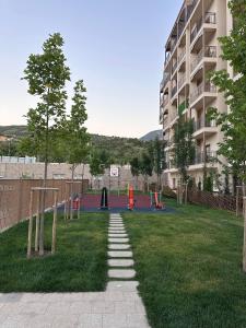 a grassy area with a playground in front of a building at Chorvoq Darvozasi touristic complex in Chorwoq