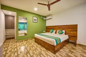 a bedroom with a bed and a green wall at Treebo Lands End Beach Resort - 100m From Morjim Beach in Morjim