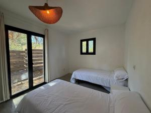 a bedroom with two beds and a large window at Can Jondalet in Sant Josep