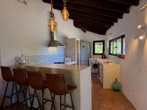 a kitchen with a counter and stools in a room at Can Jondalet in Sant Josep