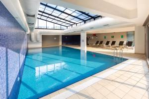 a large swimming pool with blue water in a building at Fraser Place Antasya Istanbul in Istanbul