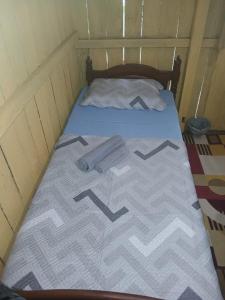 a bed in a small room with a bedspread with arrows on it at Hospedagem coqueioros in Soure