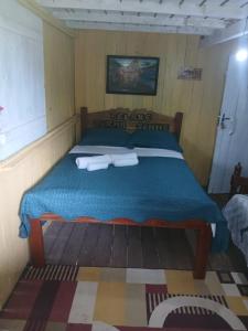 a bed in a room with two towels on it at Hospedagem coqueioros in Soure