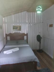 a bedroom with a bed with two towels on it at Hospedagem coqueioros in Soure