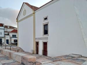 a white building with a window and a door at Casa do Tejo de Alcochete in Alcochete