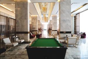 a pool table in a hotel lobby with chairs and a pool table at Hermann Hotel Pattaya in Pattaya