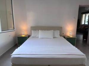 a bedroom with a large white bed with two night stands at Casa Crystallia in Chalkida