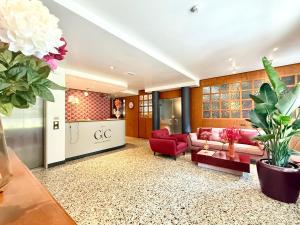 ein Wohnzimmer mit einer Couch und einem roten Sessel in der Unterkunft Hotel Gran Casa in Oderzo
