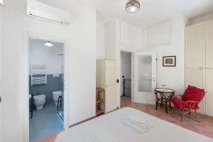 a white room with a red chair and a table at Appartamento Anna in Meta