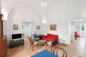 a living room with a red couch and chairs at Appartamento Anna in Meta