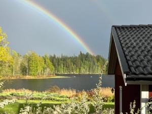a rainbow over a lake next to a house at Lake House Rågeboda in Södra Rågeboda +13 photos
